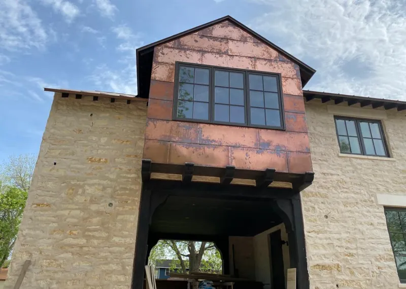 Copper metal panel facade on a stone building for Roof Repair in Darby